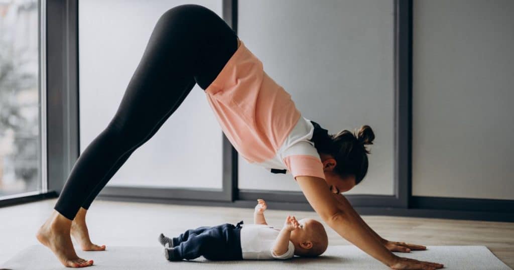 Mama-Baby Yoga Mother with baby doing yoga downward facing dog